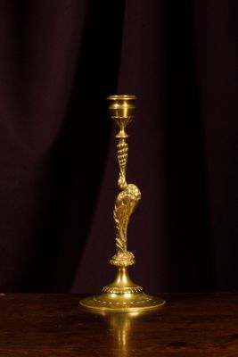 un bougeoir en or posé sur une table en bois