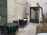a patio with tables and chairs and a table with a green table cloth on it