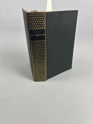 un livre noir posé sur une table blanche