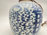 a blue and white vase with a handle on a table