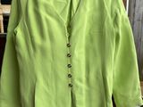 une veste vert citron suspendue à un cintre devant une fenêtre