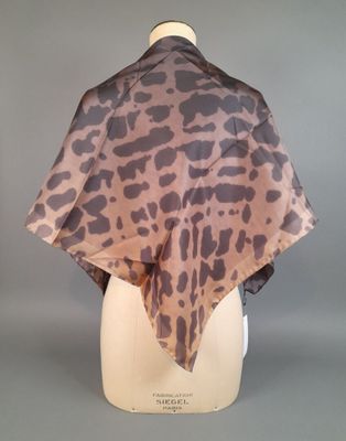 a brown and black leopard print scarf on a mannequin head