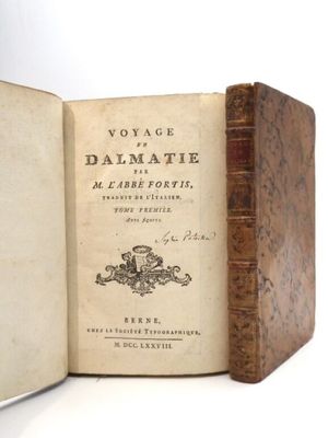 un vieux livre ouvert sur une surface blanche