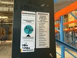 a snowboard with stickers on it in a warehouse