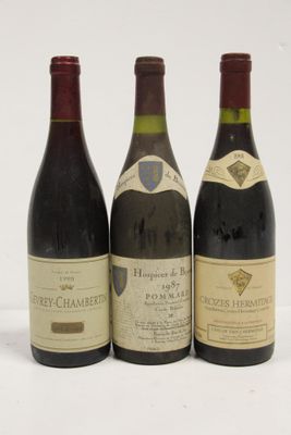 trois bouteilles de vin sont alignées sur une surface blanche