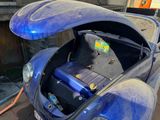 a blue car with a battery in the trunk of it