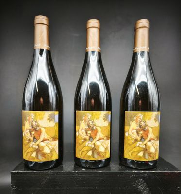 trois bouteilles de vin posées sur une table en bois