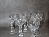 quatre verres à vin vides sont alignés sur une surface grise