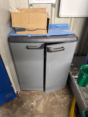 une boîte posée sur un réfrigérateur, dans un coin de la pièce