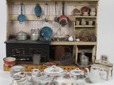 une cuisine de maison de poupées avec de nombreux objets posés sur la table