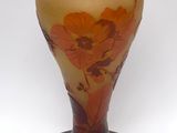 a glass vase with a flower design on it on a black stand