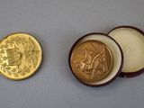 two gold coins sitting next to each other on a table