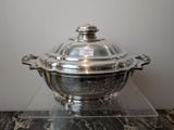 a silver plate with a glass lid on a marble table