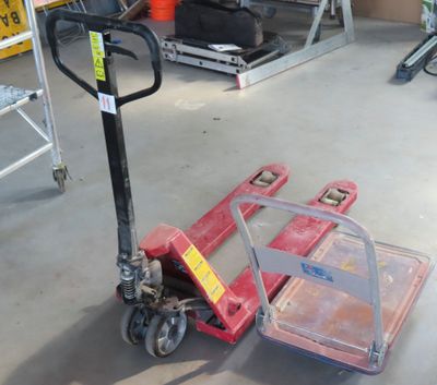 un diable rouge posé par terre dans un garage