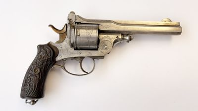 gros plan d'un revolver sur une surface blanche