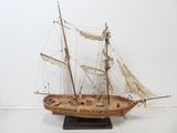 a wooden model of a sailboat on a stand