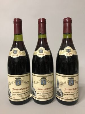 trois bouteilles de vin posées sur une table l'une à côté de l'autre