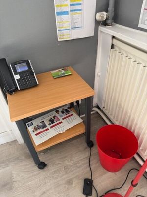 a red bucket and a red mop sitting on a table next to a phone