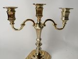 a brass plated candelab with two candles on a stand