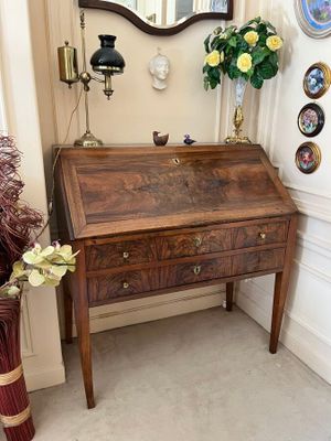 a small desk with a mirror and a vase of flowers