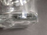 a close up of a clear glass with a black writing on it