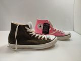 a pair of black and pink converses on a white surface
