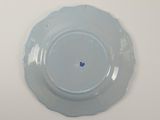 a plate with a blue flower on it on a white table