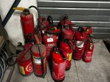 Plusieurs extincteurs sont alignés sur le sol devant une porte de garage
