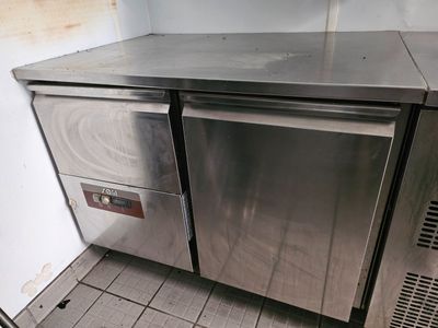 a stainless steel counter top in a kitchen with tile flooring