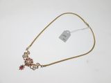 a close up of a gold necklace with a cross on it