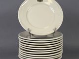 plusieurs assiettes blanches empilées les unes sur les autres sur une surface grise