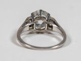 a close up of a diamond ring on a white surface