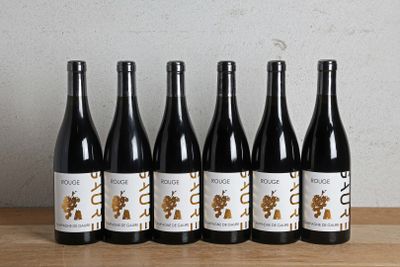 six bouteilles de vin sont alignées sur une table en bois