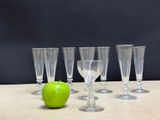 several empty wine glasses and an apple sit on a table