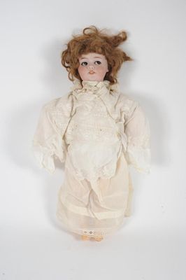 an antique doll with red hair and white dress on a white background