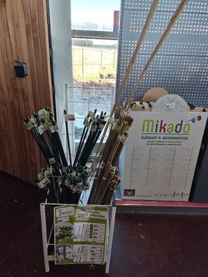 a vase with sticks in it on the floor next to a sign