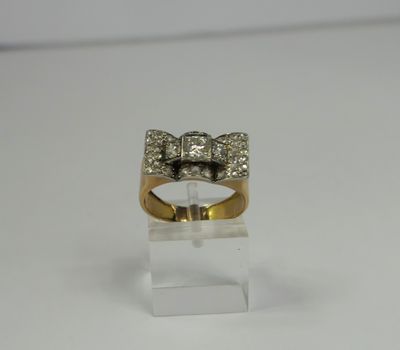 a close up of a gold ring with a bow on top of it