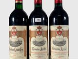 trois bouteilles de vin sont alignées sur une surface blanche
