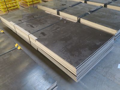 une grande pile de tôles d'acier dans un entrepôt