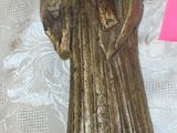 a figurine of a monk on a table next to a piece of paper