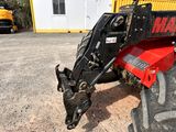 a tractor that is parked in the dirt near a building