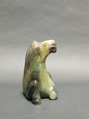 a figurine of a bear sitting on the ground