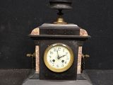 a small clock that is sitting on a black table