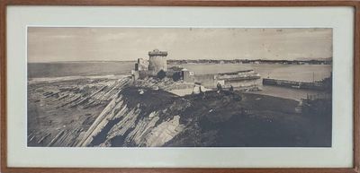 une vieille photo représentant un phare sur un rivage rocheux