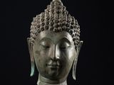 une tête de Bouddha en bronze sur fond noir