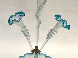 a glass vase with blue flowers in it on a white surface