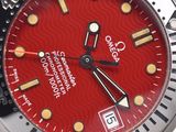 a close up of a watch with a red dial