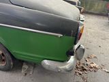 a small green truck parked on the side of the street