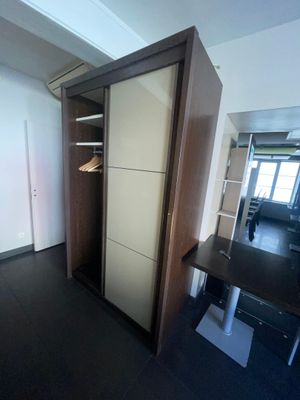 un placard situé dans un coin d'une pièce où se trouvent un bureau et une chaise