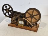 an old fashioned sewing machine on a wooden stand on a white surface